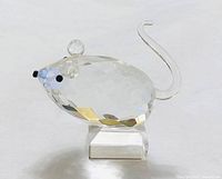 Full view of clear faceted crystal mouse figurine showing body, pedestal base, ears, eyes, and tail