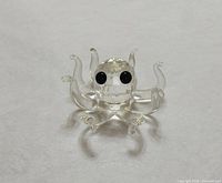 Front view of clear faceted crystal octopus figurine showing body, eight tentacles and black eyes