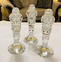 Three cut crystal shakers standing to show overall design