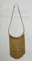 Full view of Steve Madden gold-tone fringe necklace on flat surface