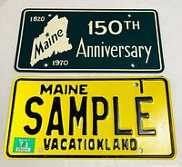 Top green Maine 150th Anniversary plate and bottom yellow SAMPLE VACATIONLAND plate shown front view