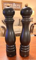 Front view of both black Peugeot mills standing side by side on table