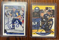 Overview of both autographed cards in sleeves