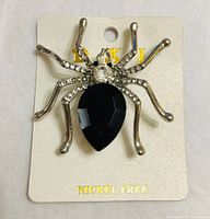Front view of spider brooch on card