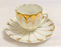 Cup on saucer, front view shows gold baroque pattern
