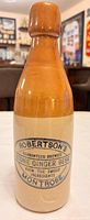 Full view of two-tone Robertson's stoneware ginger beer bottle showing printed label