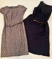 Front view of both dresses side by side displaying colors, belts, and overall condition