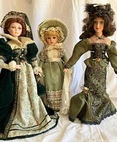 Front view of all three porcelain dolls on stands