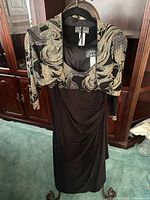 Jacket displayed over matching gown on hanger