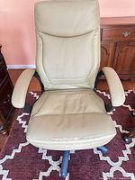 Front view of office chair showing overall design and visible wear on armrests and seat