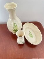 Tall vase, small bud vase and oval tray displayed together, showing basketweave texture and shamrock motif