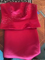 Red Bill Levkoff strapless floor-length gown folded to show embellished bodice and skirt