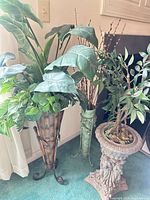 Three decorative planters with artificial plants grouped together