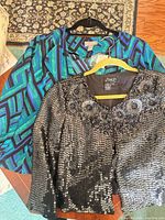 Both jackets on hangers showing patterns and sequins