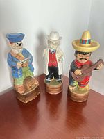 All three ceramic figural decanters on table