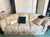 Front view of floral three-seat sofa with pillows