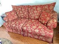 Front angled view of patterned loveseat with pillows