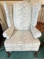 Front view showing upholstery pattern, wings, cushion, cabriole legs