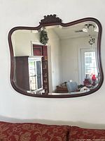 Full view of wall mirror showing shape, frame finish and size context
