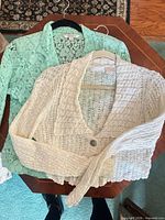 Mint blazer and cream cardigan laid out together