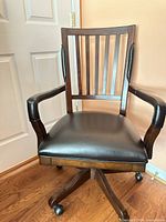Front view of wooden office chair showing slat back, upholstered seat and arms