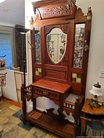 Full view of hallstand showing mirrors, hooks, drawer, tile inlays, umbrella stands, lower shelf