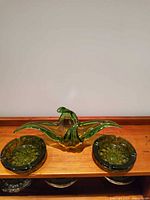 Front view of Murano bowl flanked by two ashtrays on wooden surface