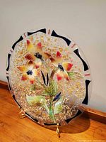 Front view of round fused glass plate with floral design