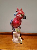 Front view of glazed ceramic parrot on base