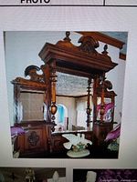 Front view of ornate mahogany over-mantel mirror showing carved crest, columns and mirrors