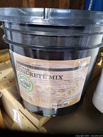 Black plastic pail labelled Artisan Concrete Mix