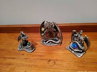 Front view of three Tudor Mint Myth & Magic pewter dragon figurines showing design details and colored glass orbs