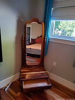 Side stand with attached mirror and open drawer