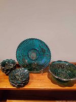 Stack of six small scalloped dessert bowls, large ribbed platter on stand, large scalloped serving bowl