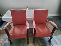 Front view of two matching coral upholstered walnut armchairs