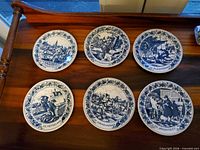 Six Delft blue plates with occupational scenes