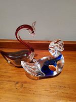 Red swan and blue duck side by side front view