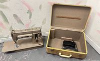 Singer sewing machine with case open showing foot pedal inside