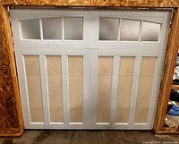Front view of assembled single-car garage door in wooden frame