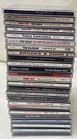 Stacked view of CD spines showing artist names and album titles