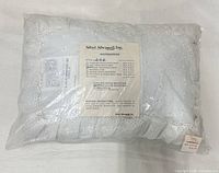 Front view of sealed white eyelet boudoir sham package with label