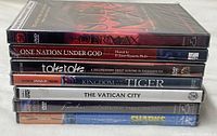 Stack of seven sealed DVD cases showing titles on spines