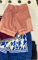 Coral Nike shorts, burgundy Nike shorts, blue lightning pattern shorts