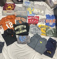 All garments spread out on sheet, schools and graphics visible