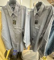 Front view of both blue Alfani shirts hanging with tags visible