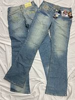 Both pairs of Dereon jeans laid flat showing full length and wash