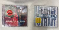 Front covers of both sealed George Strait CDs.