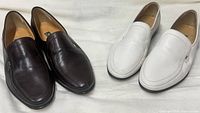 Both pairs side by side, brown and white loafers