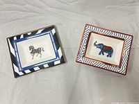 Top view of both decorative plates showing zebra and elephant designs