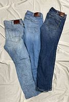 Rear view of three jeans light, medium, dark washes